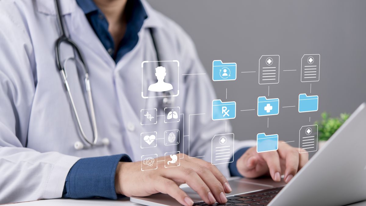 طبيب يستخدم حاسوباً محمولاً مع ظهور رموز رقمية تمثل السجلات الطبية 