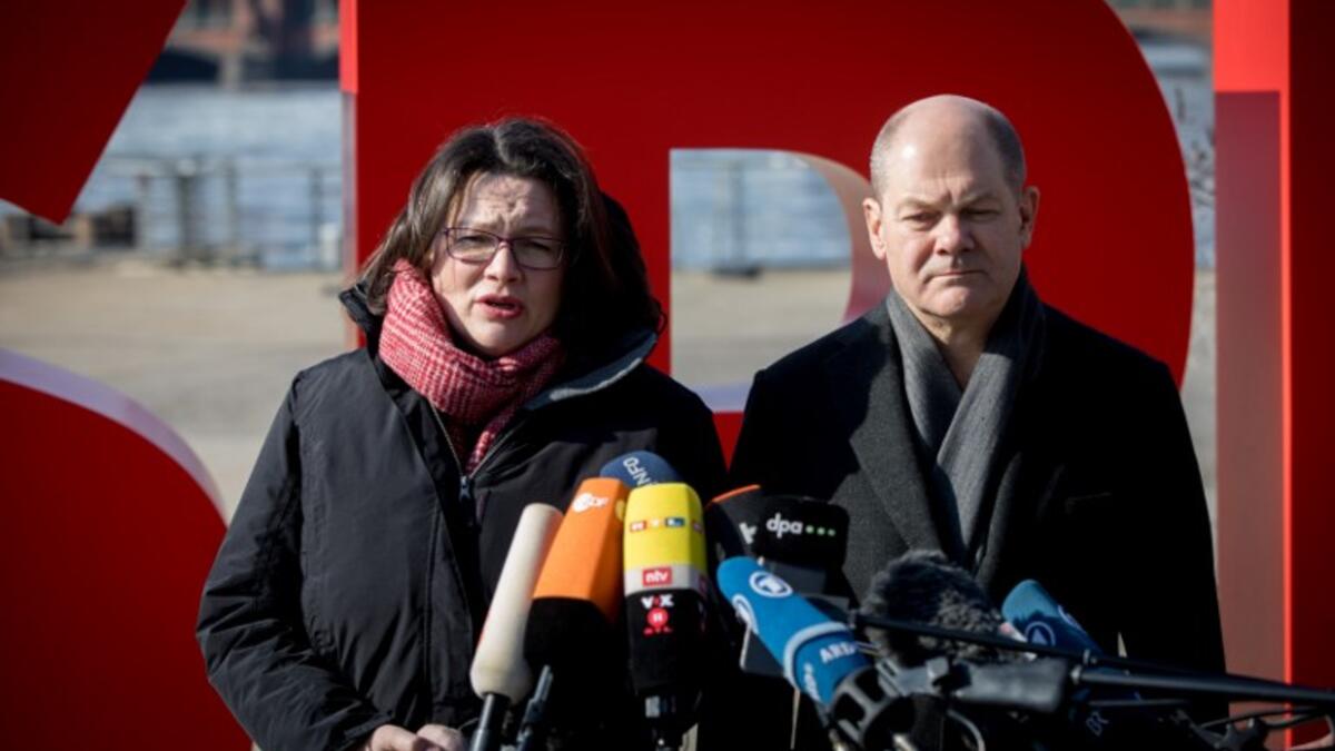 Andrea Nahles (L), parliamentary group leader of Germany's social democratic SPD party, and Hamburg's mayor and interim SPD leader Olaf Scholz stand in front of their party's logo as they give a statement, before counting starts of the ballots of their party members.
(Kay NIETFELD / DPA / AFP)