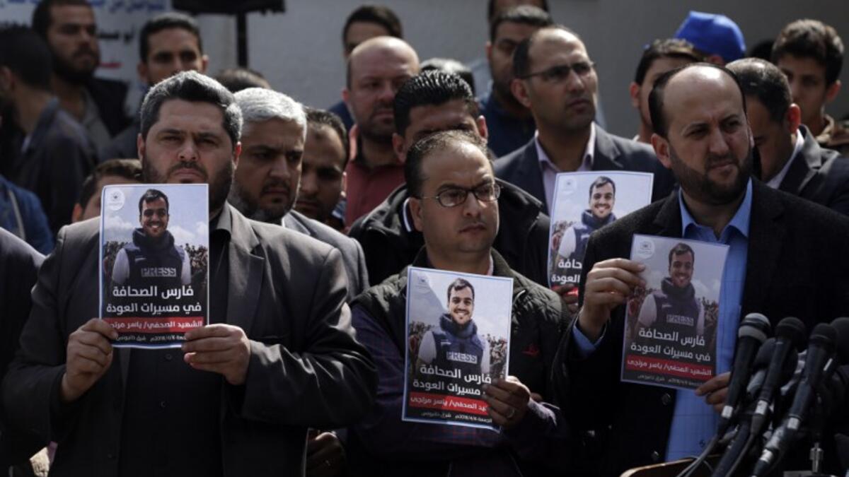 Palestinian journalists carry a portrait of journalist Yasser Murtaja, during his funeral in Gaza City on Apr. 7, 2018. (MAHMUD HAMS / AFP)