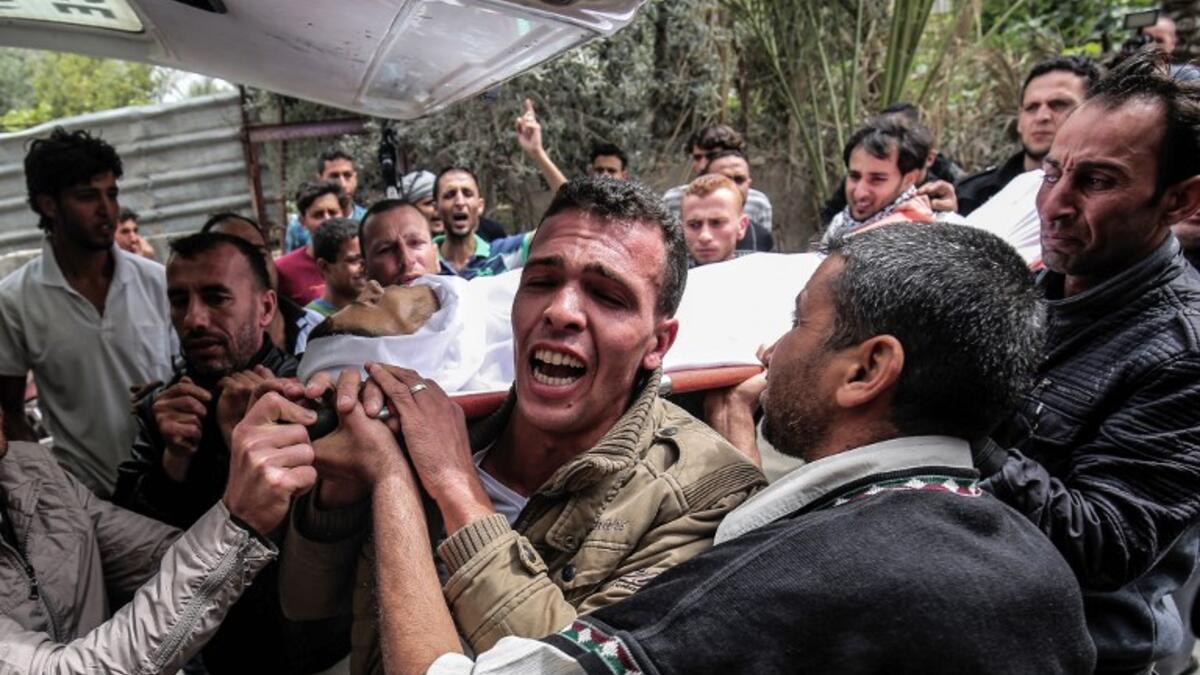 Mourners carry the body of 29-year-old Saadi Abu Taha who was killed during clashes along the Israel-Gaza border, as they walk in a funerary procession in Khan Yunis in the southern Gaza strip on Apr. 21, 2018. 
(SAID KHATIB / AFP)