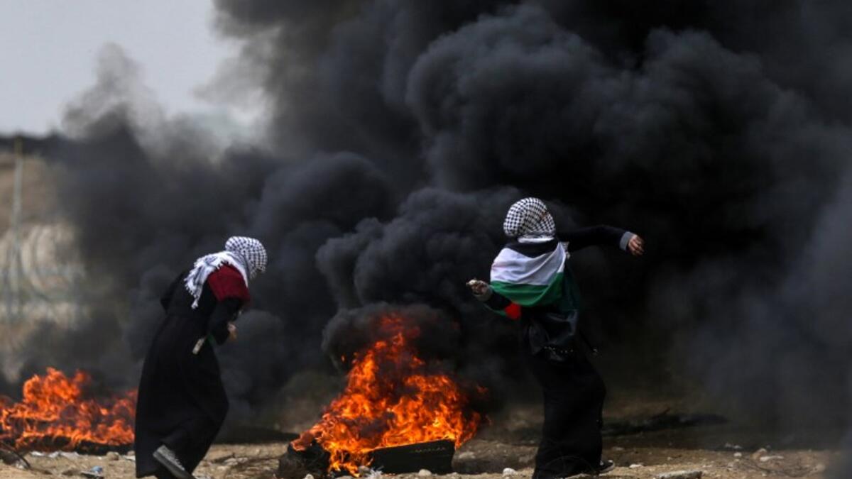 Female Palestinian protesters hurl stones towards Israeli forces during clashes along the border with the Gaza strip east of Gaza City on May 4, 2018, on the sixth straight Friday of mass demonstrations calling for the right to return to their historic homelands. (MAHMUD HAMS / AFP)