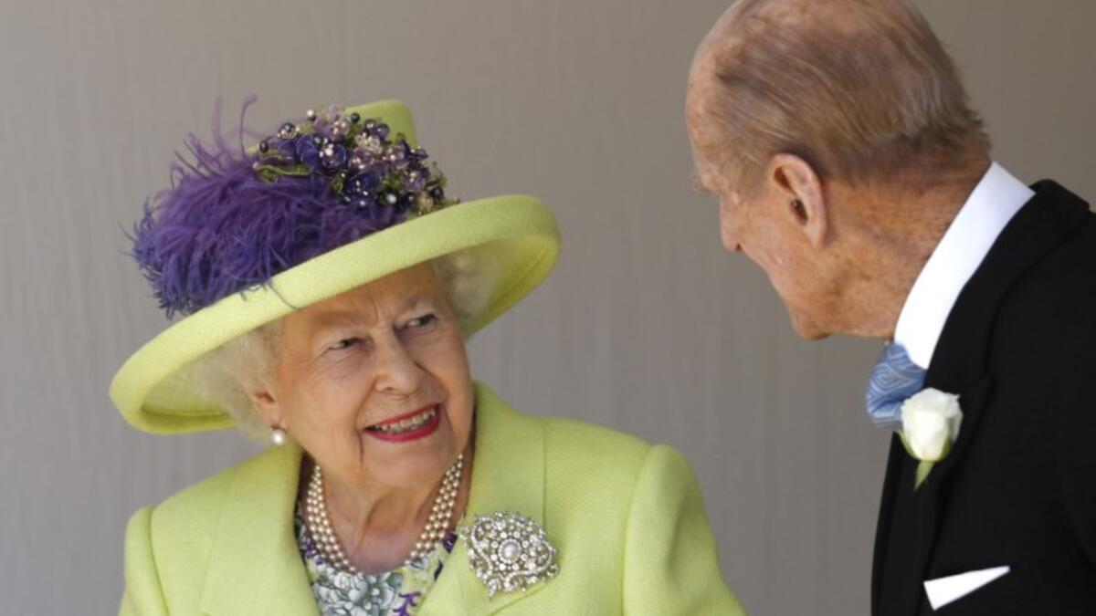 Britain's Queen Elizabeth II (L) talks with Britain's Prince Philip, Duke of Edinburgh (R) as they leave after attending the wedding ceremony of Britain's Prince Harry, Duke of Sussex and US actress Meghan Markle at St George's Chapel, Windsor Castle, in Windsor, on May 19, 2018. 
Alastair Grant / AFP