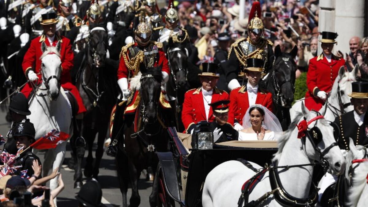 Britain's Prince Harry, Duke of Sussex and his wife Meghan, Duchess of Sussex travel in the Ascot Landau Carriage during their carriage procession on the High Street in Windsor, on May 19, 2018 after their wedding ceremony.
Adrian DENNIS/ AFP