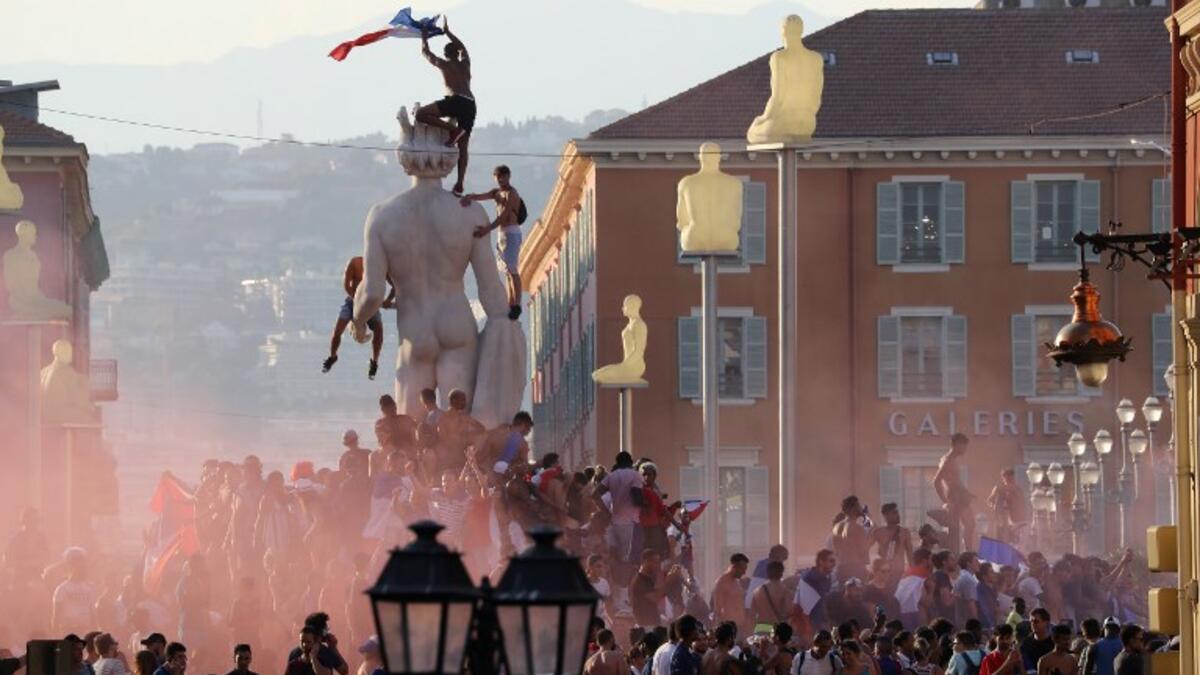 People wave a French flag and celebrate after France won the Russia 2018 World Cup final football match against Croatia, on July 15, 2018 in Nice, on the French Riviera. 
Valery HACHE / AFP