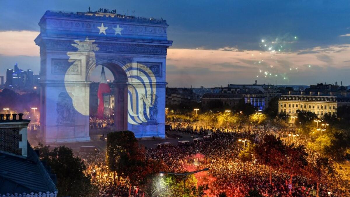 This picture taken from the terrace of the Publicis drugstore on July 15, 2018 shows a projection of the French national football team logo with two stars above on the Paris' landmark Arc de Triomphe 
GERARD JULIEN / AFP