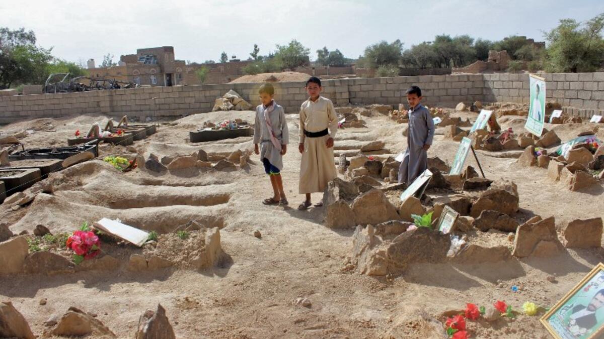 Yemeni children stand by the graves of schoolboys who were killed while on a bus that was hit by a Saudi-led coalition air strike on the Dahyan market in August, at a cemetery in the Huthi rebels' stronghold province of Saada on September 4, 2018. 
STRINGER / AFP