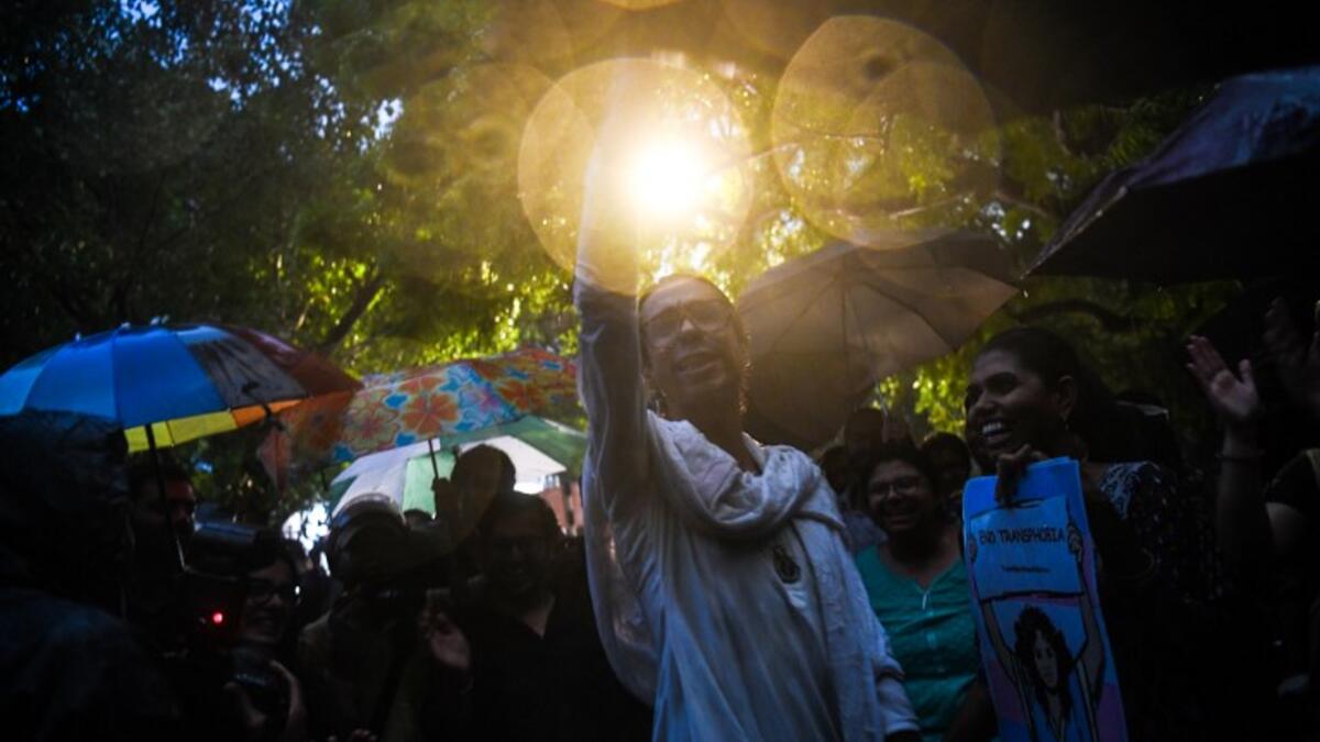 Indian members and supporters of the lesbian, gay, bisexual, transgender (LGBT) community celebrate the Supreme Court decision to strike down a colonial-era ban on gay sex, during heavy rainfall in New Delhi on September 6, 2018. 
CHANDAN KHANNA / AFP