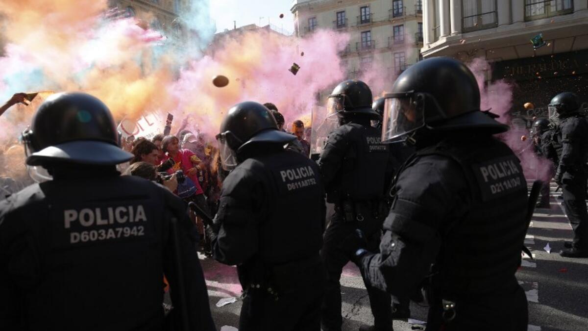 Protesters throw paint and coloured powder to Catalan regional police 'Mossos D'Esquadra' officers during a counter-protest against a demonstration in support of Spanish police in Barcelona on September 29, 2018. 
Pau Barrena / AFP