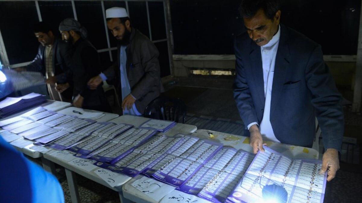 In this photo taken on October 20, 2018, Afghan Independent Election Commission (IEC) officials count ballot papers at a polling centre for the country's legislative election in Herat province. 
HOSHANG HASHIMI / AFP