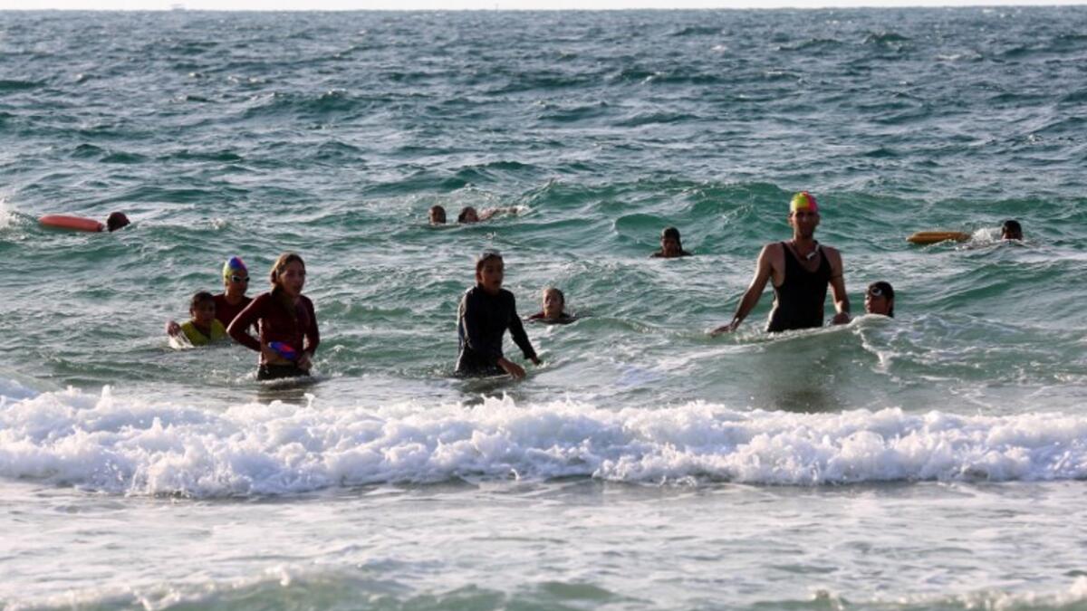On one of the world's most polluted beaches, 30 young Palestinians dive head first into the sea off the coast of Gaza, their minds filled with dreams of Olympic glory. (SAID KHATIB / AFP)