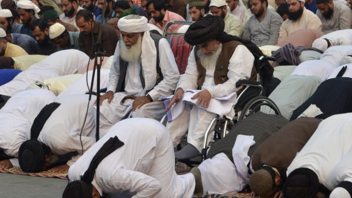 Khadim Hussain Rizvi (centre R), head of the Tehreek-e-Labaik Pakistan (TLP), a hardline religious political party, offers Friday prayers along with supporters during a protest rally in Pakistan. (ARIF ALI / AFP)
