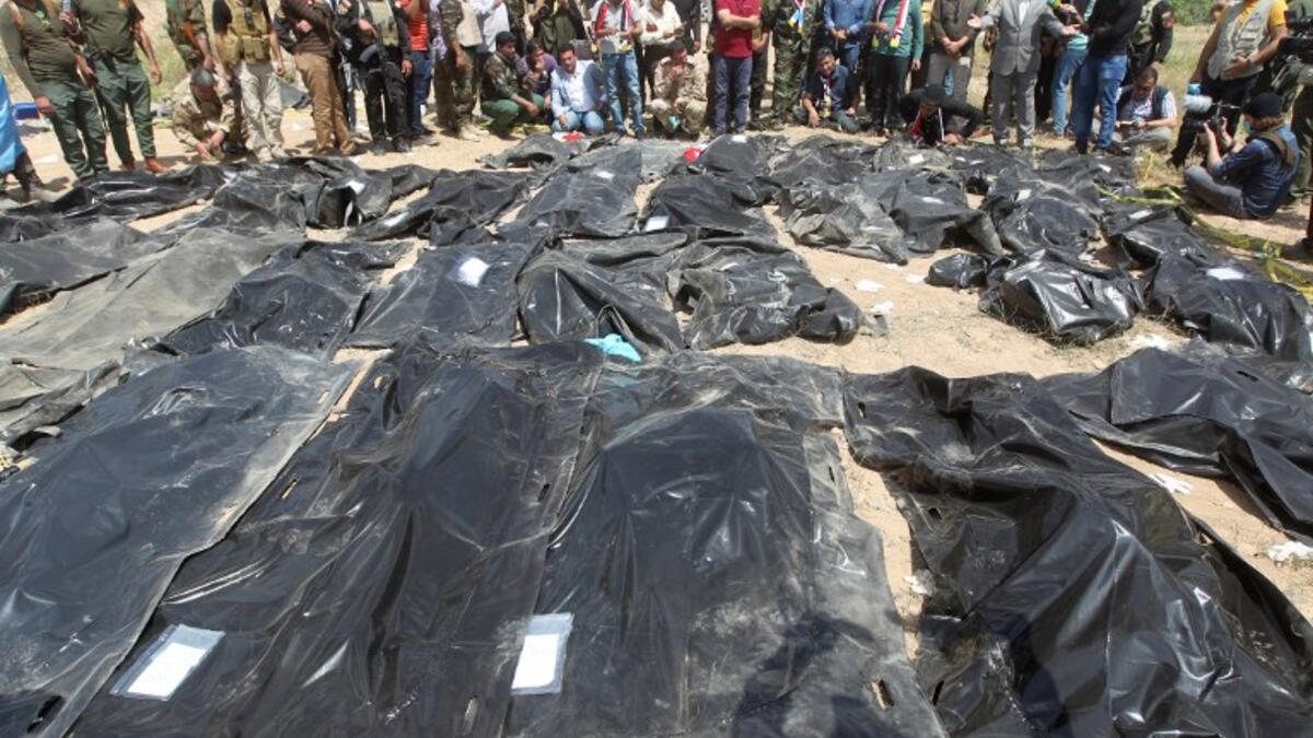 Iraqis mourn near body-bags containing the remains of people believed to have been slain by jihadists of the Islamic State (IS) group lying on the ground at the Speicher camp in the Iraqi city of Tikrit. (AHMAD AL-RUBAYE / AFP)