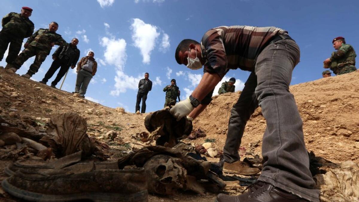 A members of the Yazidi minority search for clues, that might lead them to missing relatives in the remains of people killed by the Islamic State in Iraq. (Safin HAMED / AFP)