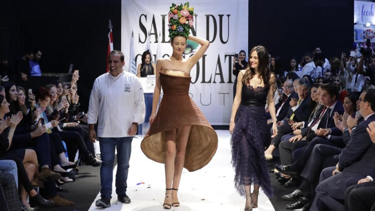 A model displays a chocolate dress created by founder of fashion brand Karoline Lang (R) at the 2018 chocolate fair fashion show in Beirut on November 8, 2018. 
JOSEPH EID / AFP