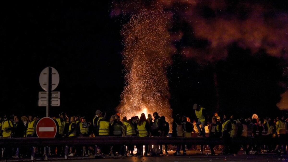 Protesters stand around a fire as they block the A10 motorway in Virsac, near Bordeaux, southwestern France, on November 18, 2018.
NICOLAS TUCAT / AFP