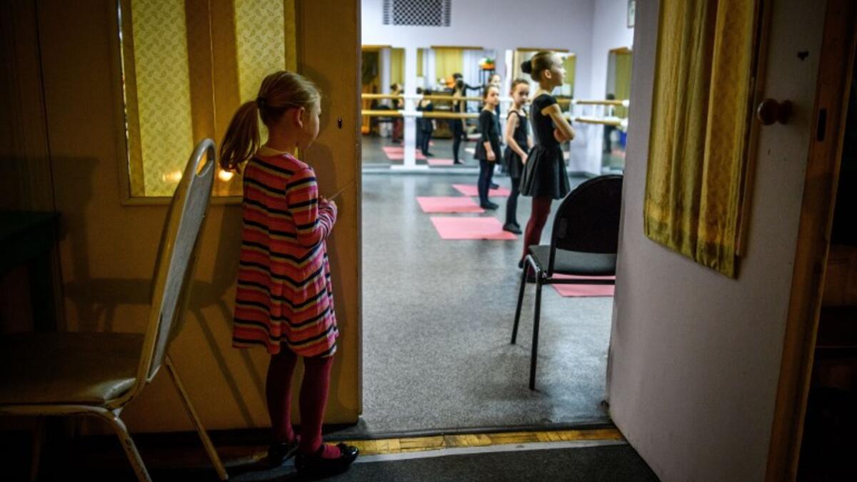 Girls attend a class at a ballet studio in Moscow on November 22, 2018. In a small studio in northern Moscow, parents and grandparents sit in a corridor waiting for children as young as three to finish their ballet class. 
Mladen ANTONOV / AFP