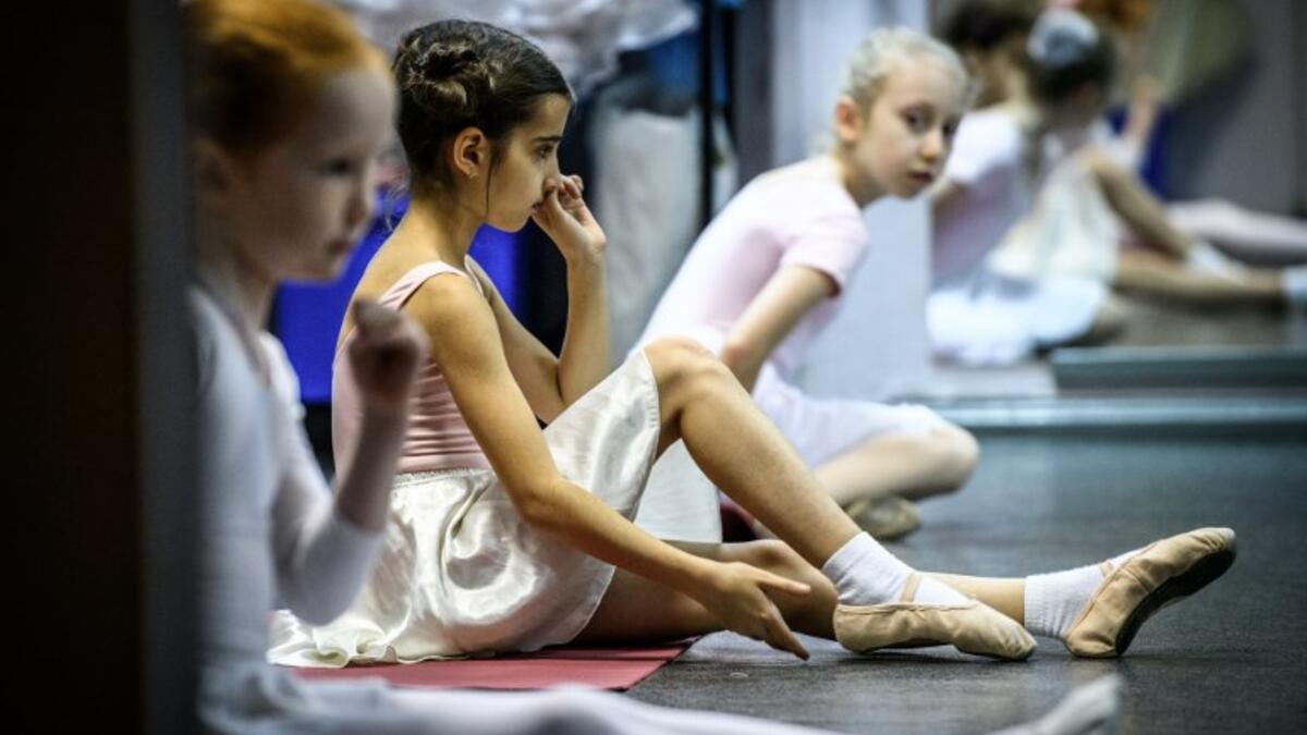 Girls attend a class at a ballet studio in Moscow on November 22, 2018. In a small studio in northern Moscow, parents and grandparents sit in a corridor waiting for children as young as three to finish their ballet class. 
Mladen ANTONOV / AFP