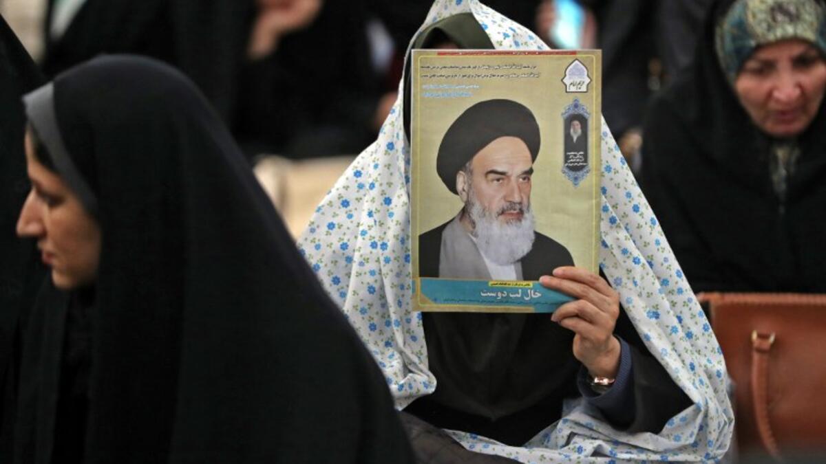 An Iranian woman holds a poster of Iran's late founder of the Islamic Republic, Ayatollah Ruhollah Khomeini
STR / AFP