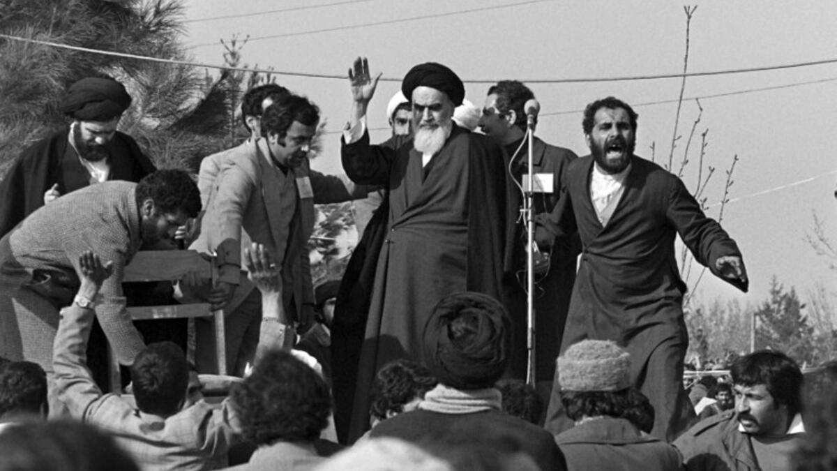Ayatollah Ruhollah Khomeini waves to a crowd of supporters gathered at the Behechte Zahra Cemetery in Tehran during his visit on the day of his return from France after 15 years of exile. GABRIEL DUVAL / AFP