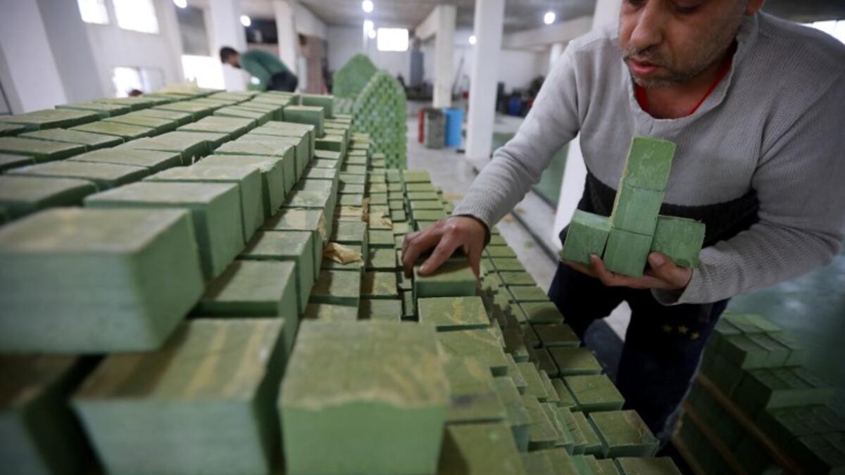 Syrian workers arrange olive soap bars in a factory on the outskirts of Aleppo 
LOUAI BESHARA / AFP