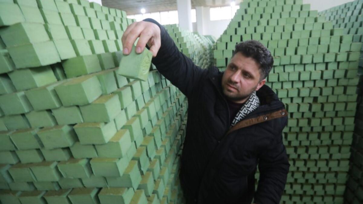 Syrian businessman Ali Shami arranges olive soap bars in a factory on the outskirts of Aleppo 
LOUAI BESHARA / AFP