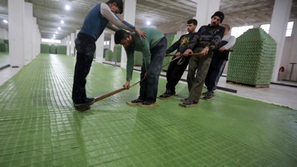 Syrian workers cut olive soap bars in a factory on the outskirts of Aleppo 
LOUAI BESHARA / AFP