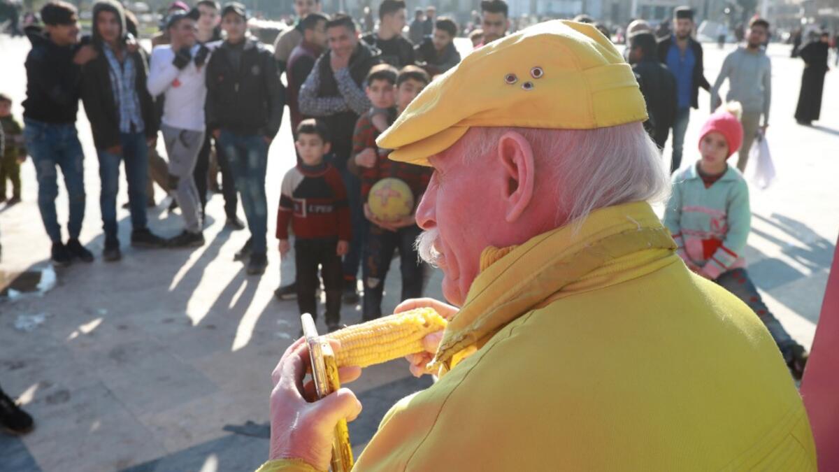 Abu Zakkour, Aleppo's so-called 'yellow man' eats a cob of corn in the northern Syrian city on February 11, 2019. Dressed in yellow from head-to-toe, Abu Zakkour is hailed as part of the "heritage" of the northern Syrian city of Aleppo, along with its medieval citadel and its ancient covered markets. 
LOUAI BESHARA / AFP
