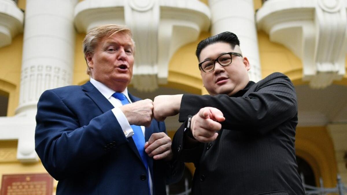 US President Donald Trump impersonator Russel White (L) and North Korean leader Kim Jong Un impersonator Howard X (R) pose together for photographs outside the Opera House in Hanoi on February 22, 2019. 
Manan VATSYAYANA / AFP