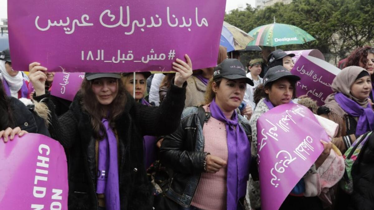 A Lebanese women hold a placards as they participate in a march against marriage before the age of 18, in the capital Beirut on March 2, 2019. The placard in Arabic reads " We do not want to find a groom for you, not before 18". 
ANWAR AMRO / AFP