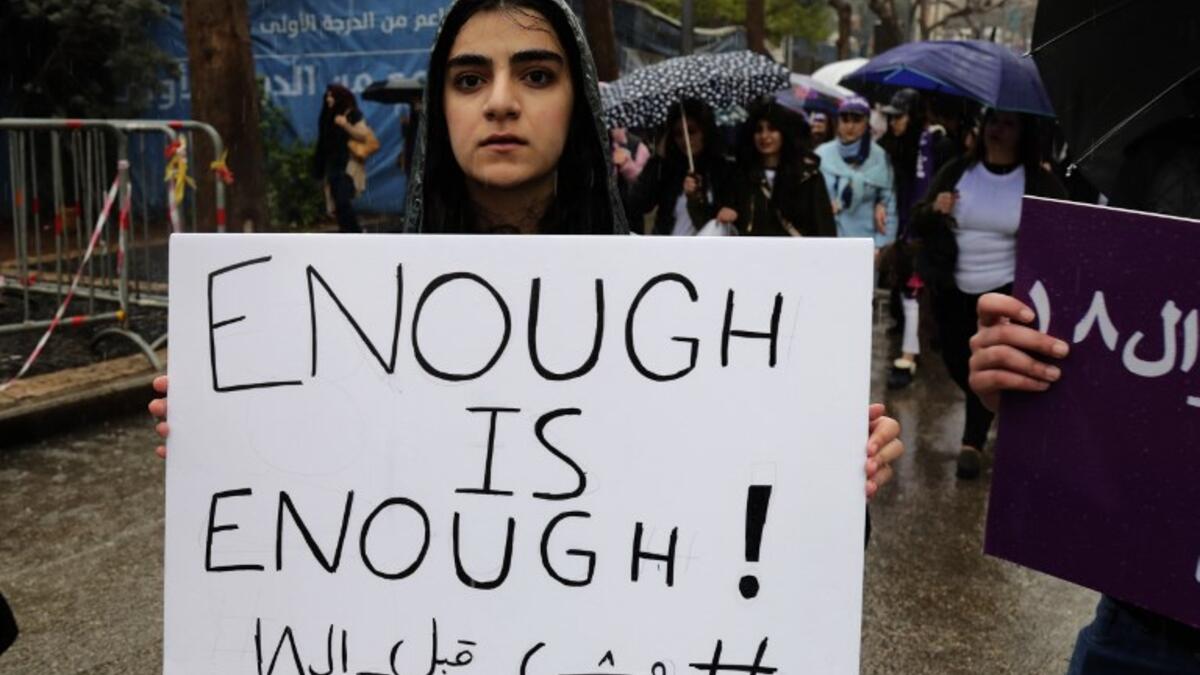 A Lebanese woman hold a placard as she participates in a march against marriage before the age of 18, in the capital Beirut on March 2, 2019. The Arabic writing on the placard reads "Not before 18". 
ANWAR AMRO / AFP