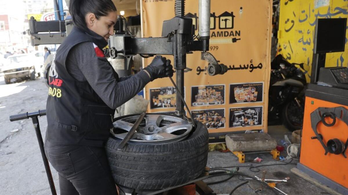 Amina repairs a flat tyre at a car tyre's repair shop in Beirut on March 8, 2019. Amina has been working for 10 years in mechanics, specially in the tyres repair business. She considers it fulfilling as she always dreamt of doing that job.
JOSEPH EID / AFP