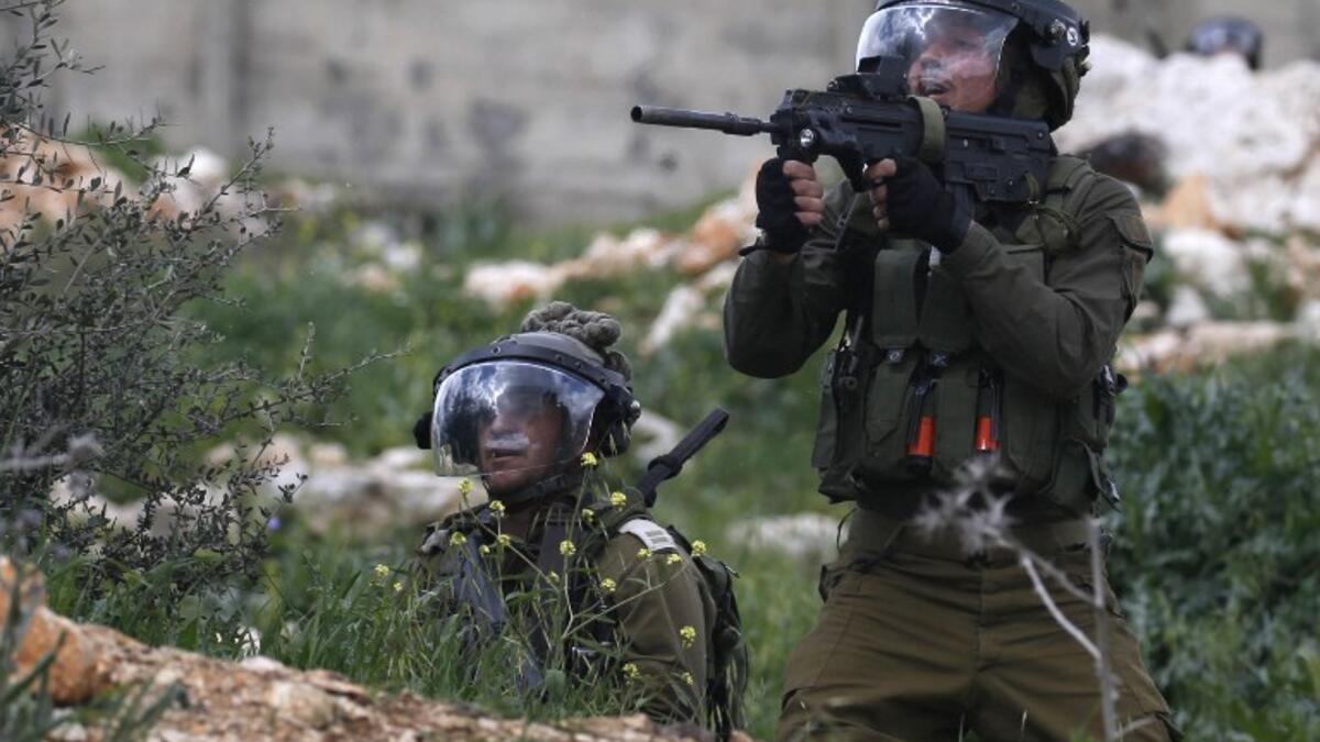 Israeli soldiers take aim at Palestinian protesters following a weekly demonstration against the expropriation of Palestinian lands in the village of Kfar Qaddum, near Nablus 
JAAFAR ASHTIYEH / AFP