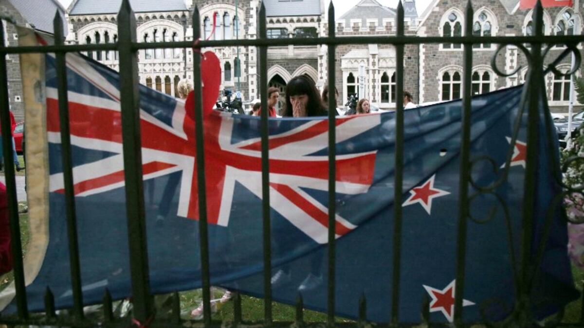 A woman reacts as as she pays her respects in front of floral tributes for victims of the March 15 mosque attacks, in Christchurch 
DAVID MOIR / AFP