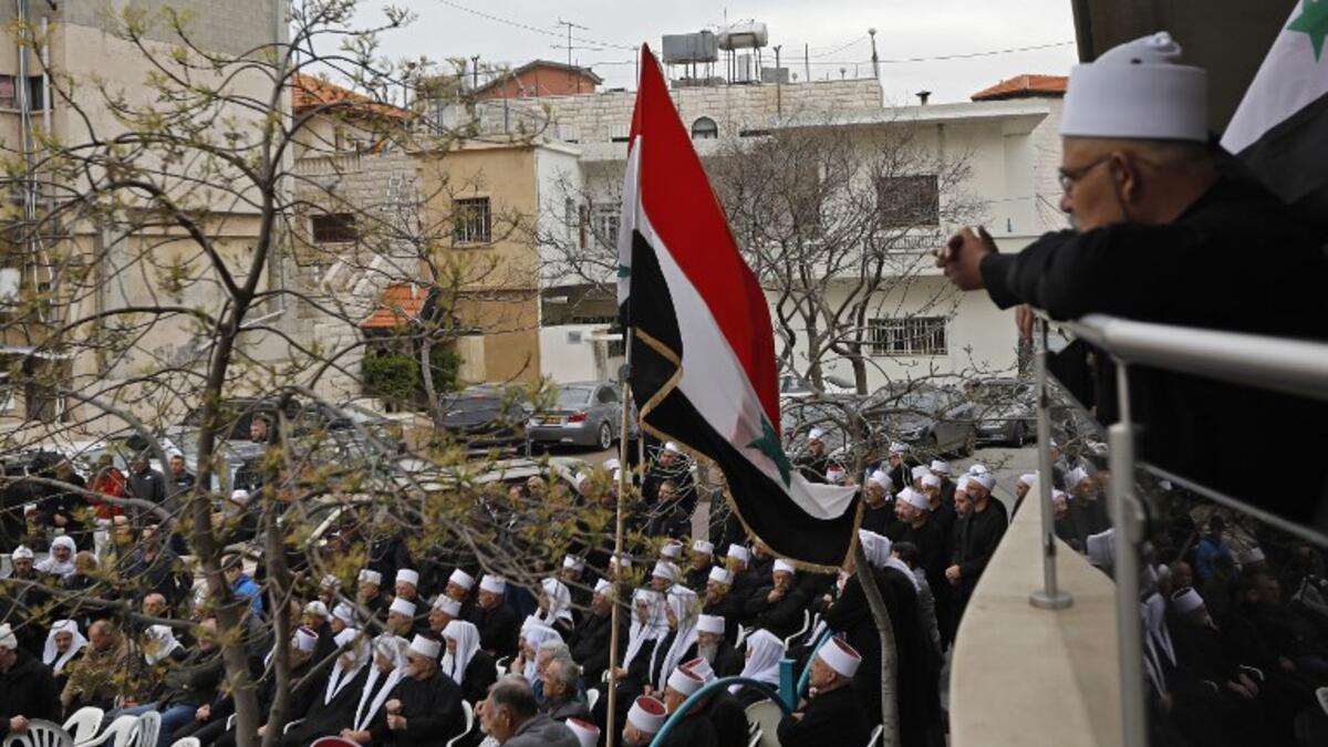 Druze residents of the Golan Heights wave Syrian flags as they protest against the backing of Israel's capture of the Golan Heights by the US president, in the village of Majdal Shams in the Israeli-annexed territory on March 23, 2019. 
Jalaa MAREY / AFP