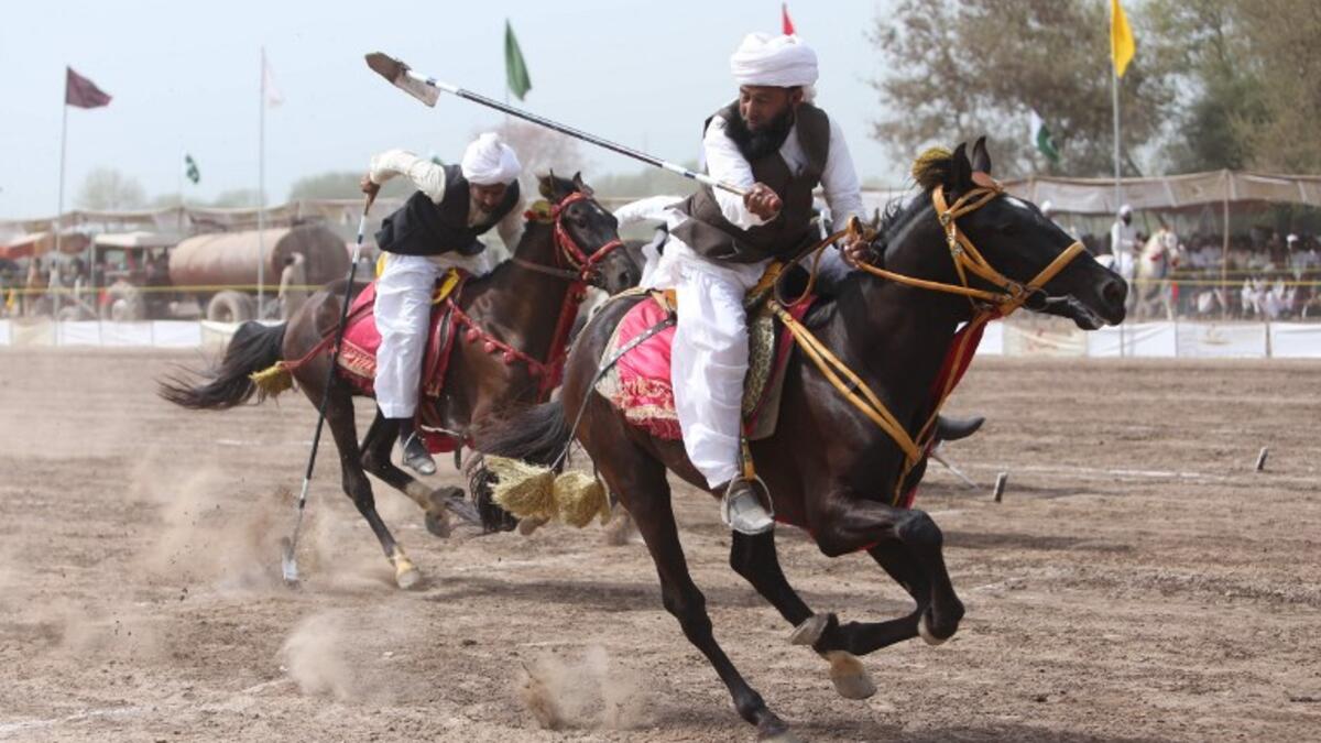 This photograph taken on March 27, 2019, shows Pakistani horse riders with lances used to pick up pegs during an attempt for a Guinness World Record for tent pegging in Khanewal district in Punjab province. 
SS MIRZA / AFP