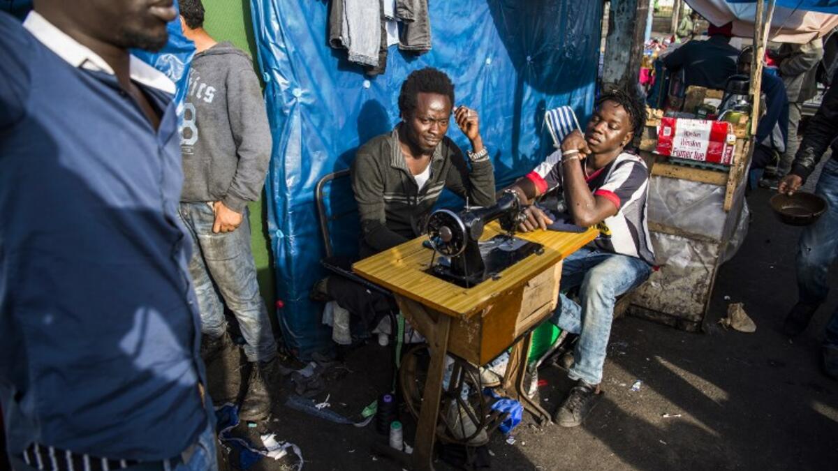Sub-Saharan migrants sit by a sewing machine at the Oulad Ziane migrant camp in Casablanca on March 27, 2019. 
FADEL SENNA / AFP