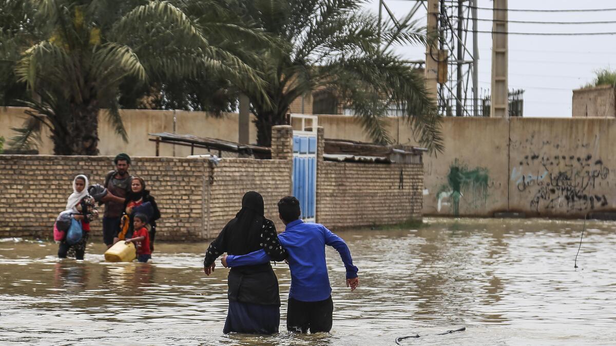 An Iranian family walks through a flooded street in a village around the city of Ahvaz, in Iran's Khuzestan province
Mehdi Pedramkhoo / TASNIM NEWS / AFP