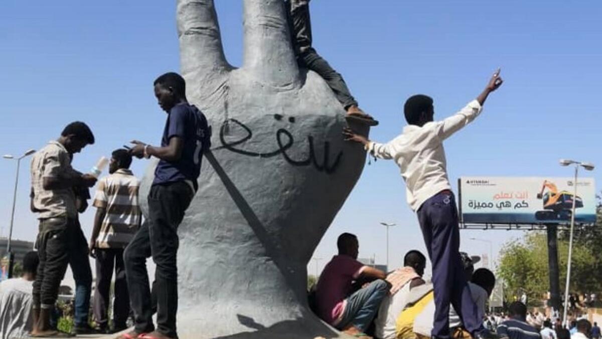 Sudanese protesters stand on a monument as others rally in the area of the military headquarters in the capital Khartoum on April 8, 2019. The writing on the monument reads in Arabic: "Victory is ours".
STRINGER / AFP