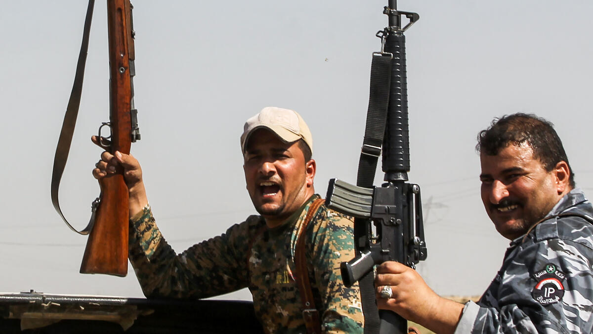 Members of the Iraqi forces pose with their rifles as they ride in the back of a pick-up truck during the advance towards villages between the northern Iraqi cities of Hawija and Kirkuk on October 6, 2017
AHMAD AL-RUBAYE / AFP