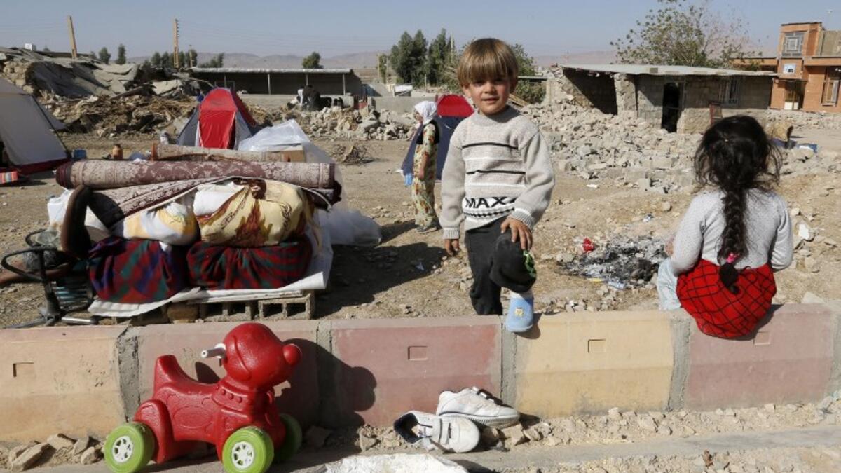 Iranian children next to the rubble of their home in Kouik village near to Sarpol-e Zahab.

(ATTA KENARE / AFP)