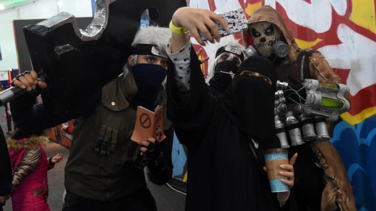 A Saudi woman uses her cell phone to take a "selfie" photograph with cosplayers while attending the first ever Comic-Con Arabia event held in the capital Riyadh on November 25, 2017. 

(FAYEZ NURELDINE / AFP)