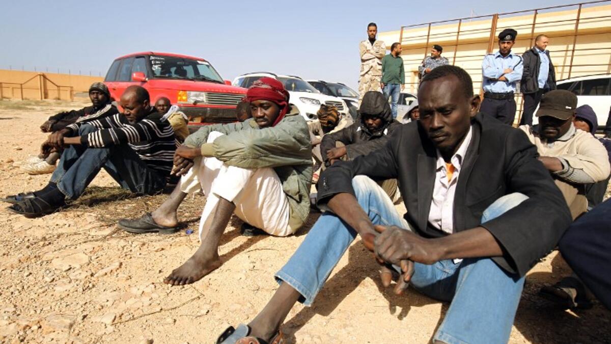 Sub-Saharan migrants sit at the Qanfouda detention center, in the southern outskirts of Benghazi, before being repatriated, on Dec. 2, 2017. 
(Abdullah DOMA / AFP)