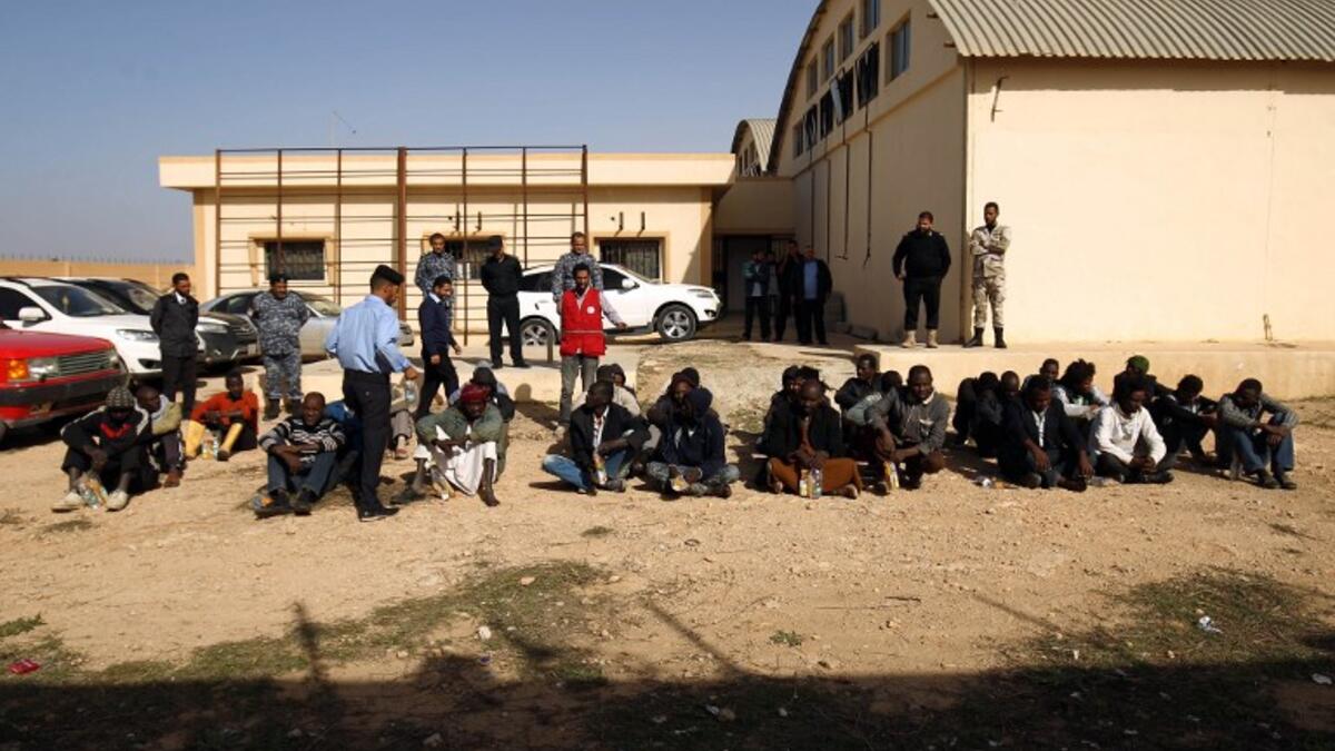 Sub-Saharan migrants sit at the Qanfouda detention center, in the southern outskirts of Benghazi, before being repatriated, on Dec. 2, 2017. 
(Abdullah DOMA / AFP)