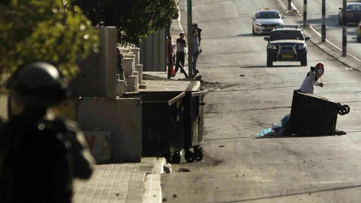 A member of the Israeli forces (L) holds a position as a Palestinian protestor throws stones during clashes following a demonstration by the Popular Front for the Liberation of Palestine (PFLP) in Bethlehem in the Israeli occupied West Bank. 
(Musa AL SHAER / AFP)