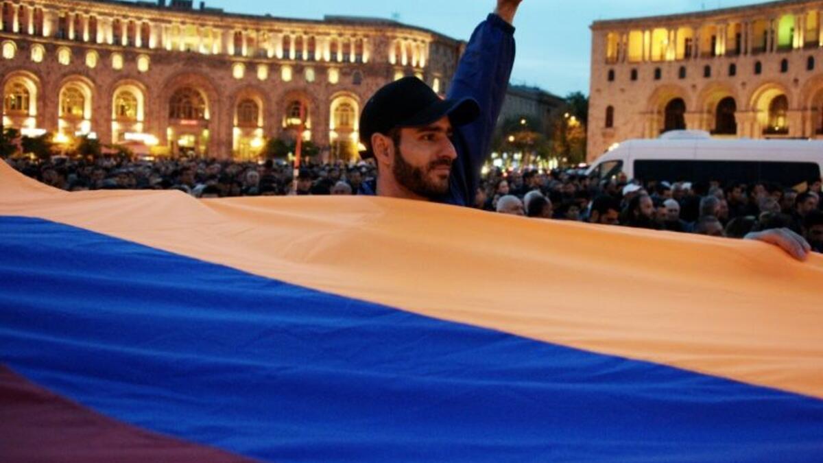 Protesters holding an Armenian flag in the main square in Yerevan  (AFP/File Photo)