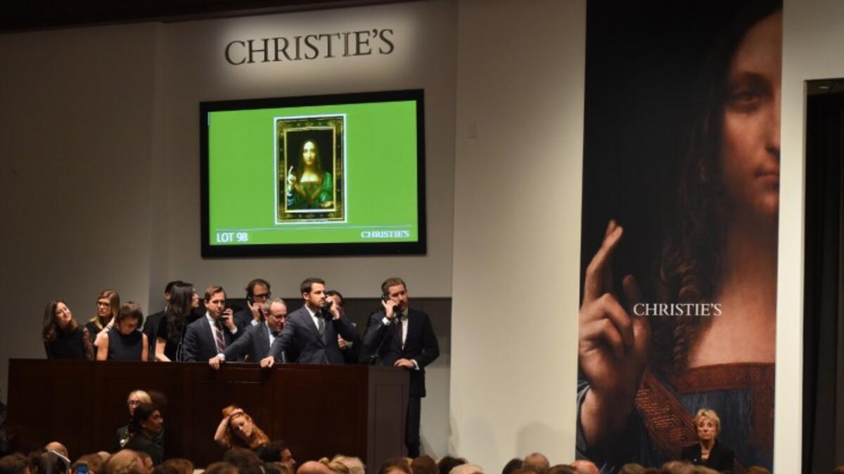 Christie's employees take bids for Leonardo da Vinci’s 'Salvator Mundi' at Christie's New York November 15, 2017. A 500-year-old work of art depicting Jesus Christ sold in New York on Wednesday for $450.3 million setting a new art auction record. (AFP/Timothy A. Clary)