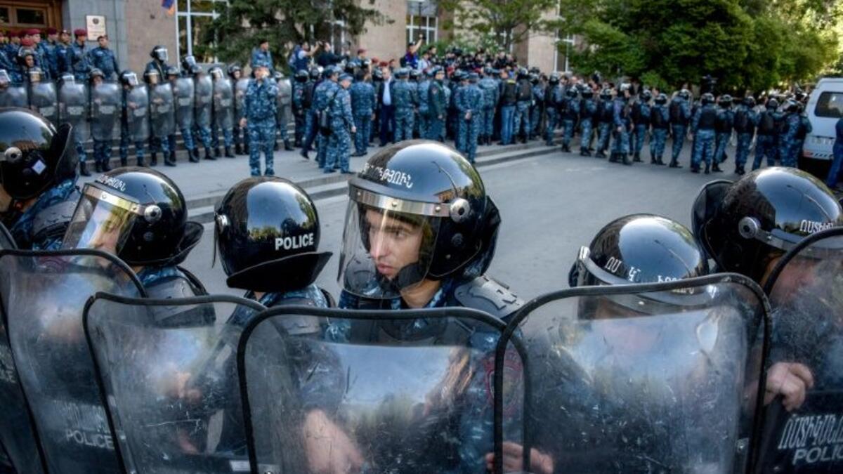 Riot police stand guard in front of the entrance to government headquarters which protestors tried to enter (AFP/File Photo)