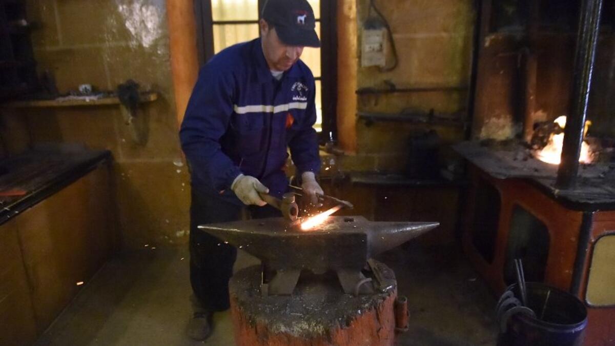 Algerian farrier Meddah Larbi hammers a horseshoe at a horse breeding farm, one of the oldest and largest farm in Algeria, perched on the high plateaux in the country's Tiaret region, 300 Kilometres west of Algiers, on April 24, 2018. 
RYAD KRAMDI / AFP