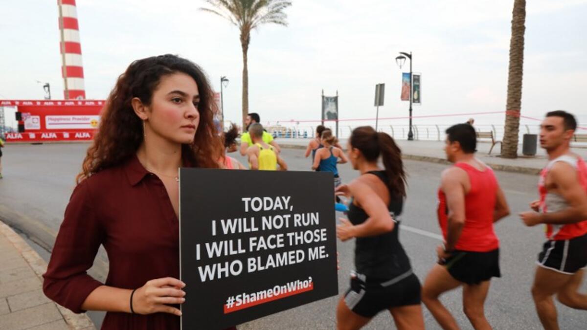 An activist holds a banner against sexual assaults during the 16th edition of the Beirut Marathon on November 11, 2018. 
ANWAR AMRO / AFP