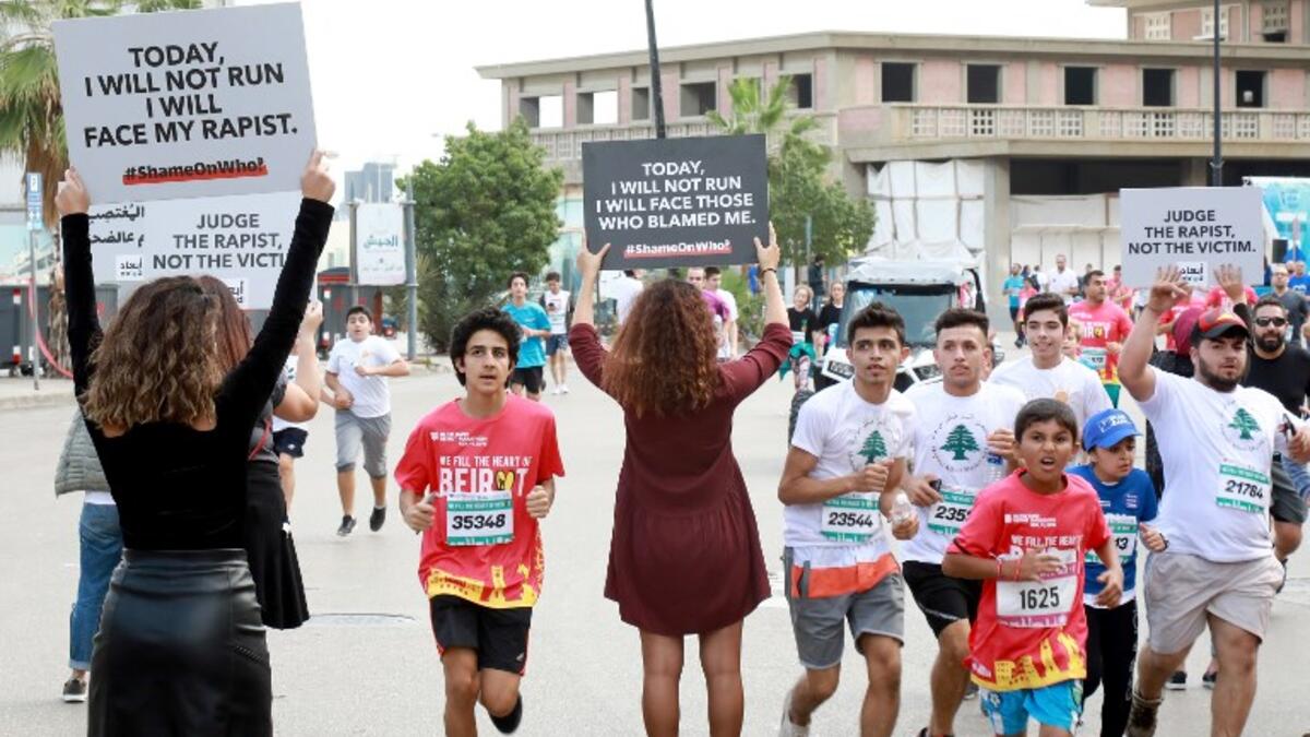 Activists hold banners against sexual assaults during the 16th edition of the Beirut Marathon on November 11, 2018. 
ANWAR AMRO / AFP